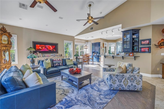 living room featuring ceiling fan, rail lighting, and lofted ceiling