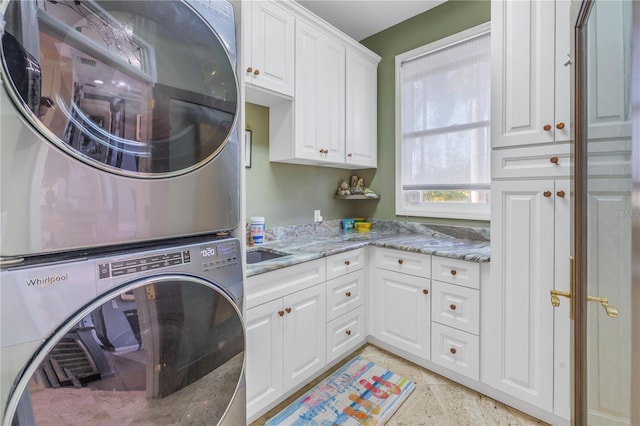 washroom featuring cabinets and stacked washer and dryer