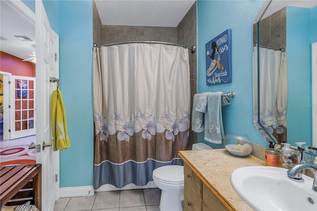 bathroom with curtained shower, toilet, vanity, and tile patterned flooring