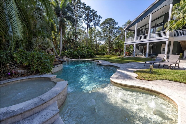 view of swimming pool featuring ceiling fan, an in ground hot tub, a sunroom, a lawn, and a patio area