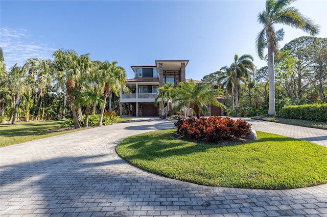 view of property's community featuring a yard and curved driveway