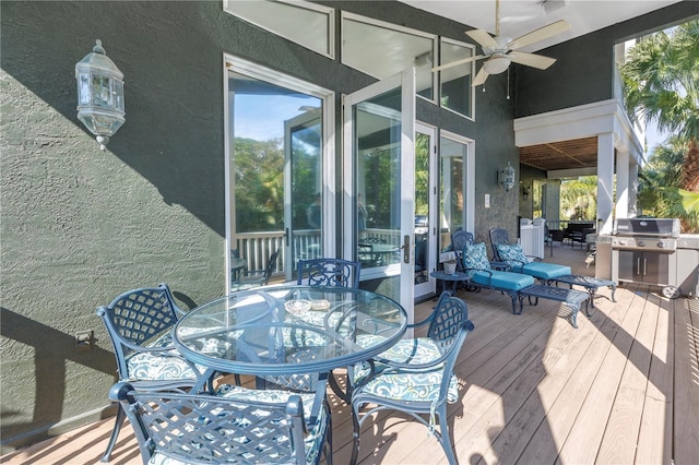 deck featuring area for grilling, a ceiling fan, and outdoor dining space