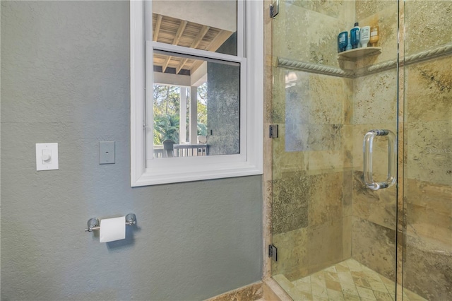 full bathroom with a stall shower and a textured wall