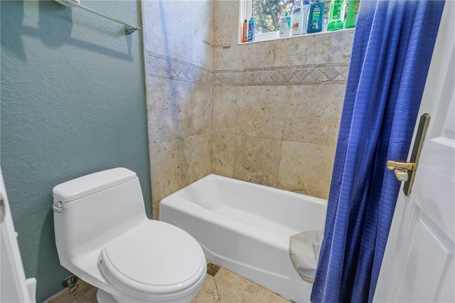 bathroom featuring shower / bath combo, a textured wall, and toilet