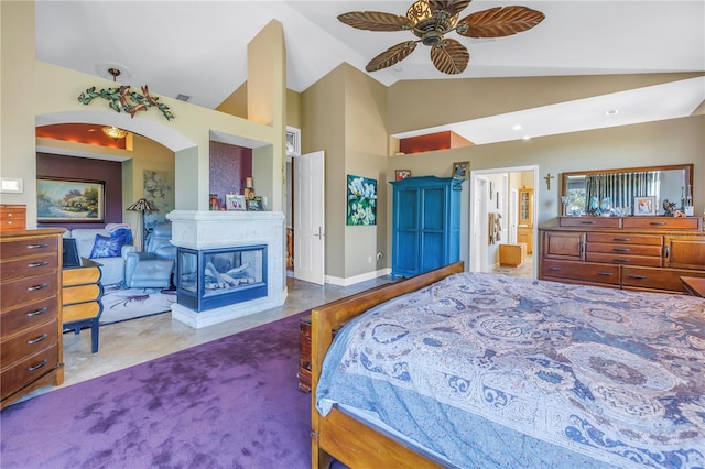 bedroom featuring ensuite bath, high vaulted ceiling, and a multi sided fireplace