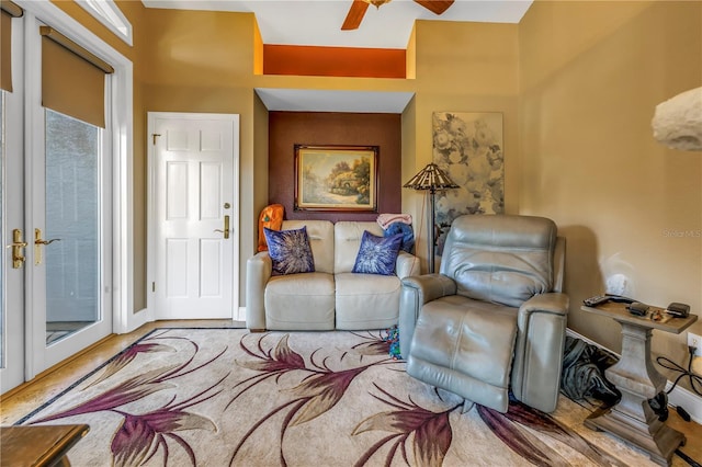 living area with ceiling fan, wood finished floors, and baseboards