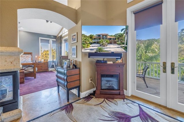 living area featuring carpet, arched walkways, and baseboards