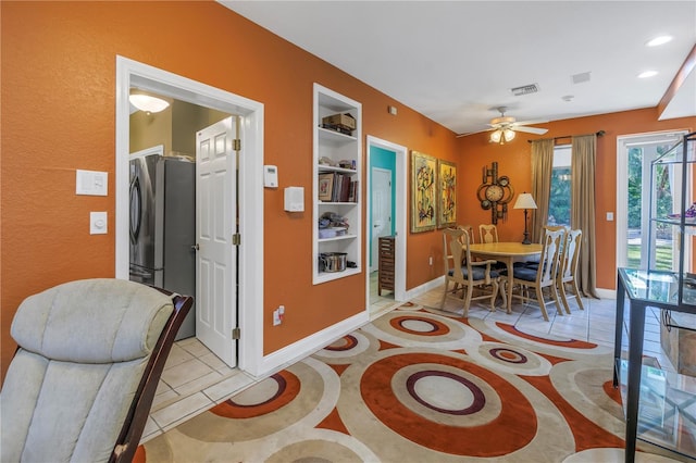 dining space with built in shelves, visible vents, baseboards, and light tile patterned floors