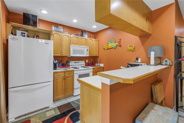 kitchen with a peninsula, white appliances, a kitchen bar, and light countertops