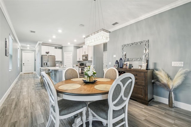 dining area with baseboards, visible vents, and crown molding