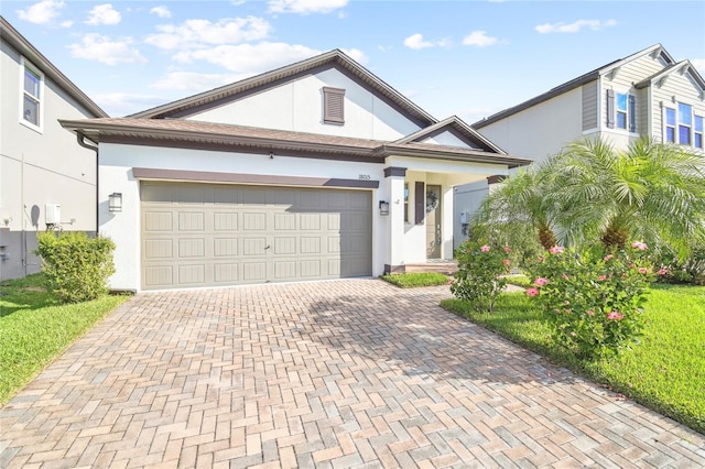 view of front facade with decorative driveway, an attached garage, and stucco siding