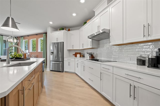 kitchen with decorative light fixtures, stainless steel appliances, sink, and white cabinetry