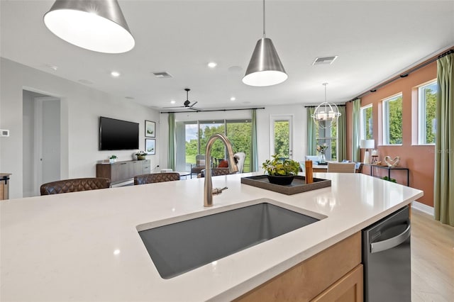 kitchen with sink, pendant lighting, dishwasher, and light brown cabinetry