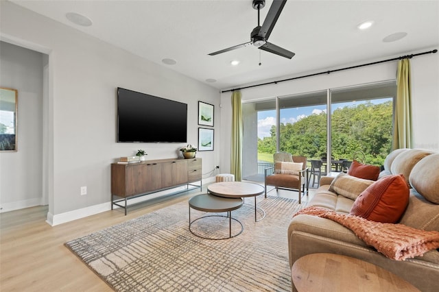 living room featuring ceiling fan and light hardwood / wood-style flooring