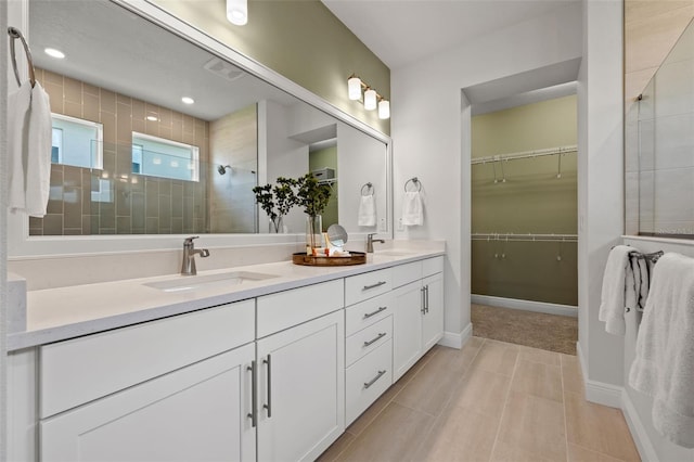 bathroom featuring a tile shower and vanity