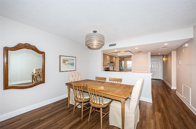 dining room featuring a textured ceiling and dark hardwood / wood-style flooring