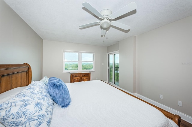 bedroom featuring access to exterior, ceiling fan, hardwood / wood-style floors, and a textured ceiling