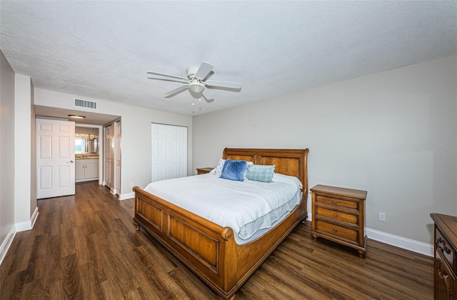 bedroom with ceiling fan, a closet, dark wood-type flooring, and a textured ceiling