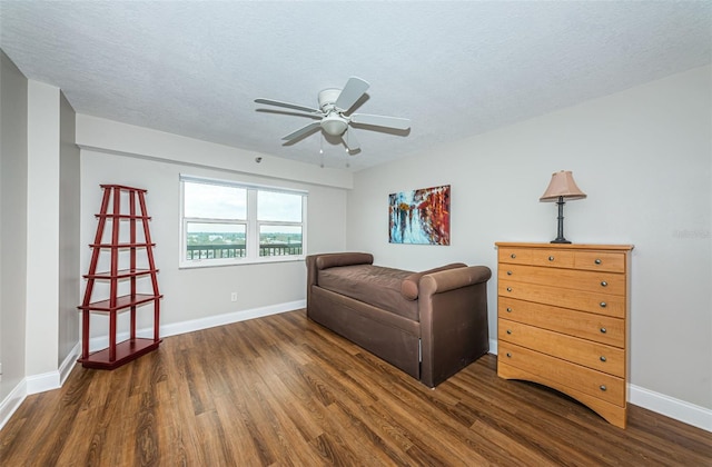 living room with dark hardwood / wood-style floors, ceiling fan, and a textured ceiling