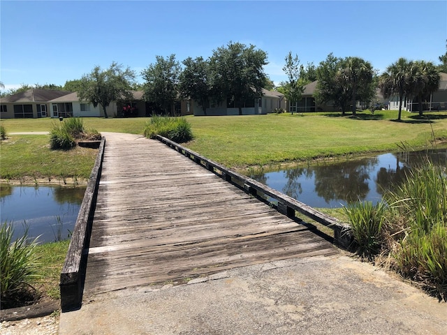 dock area with a water view and a yard