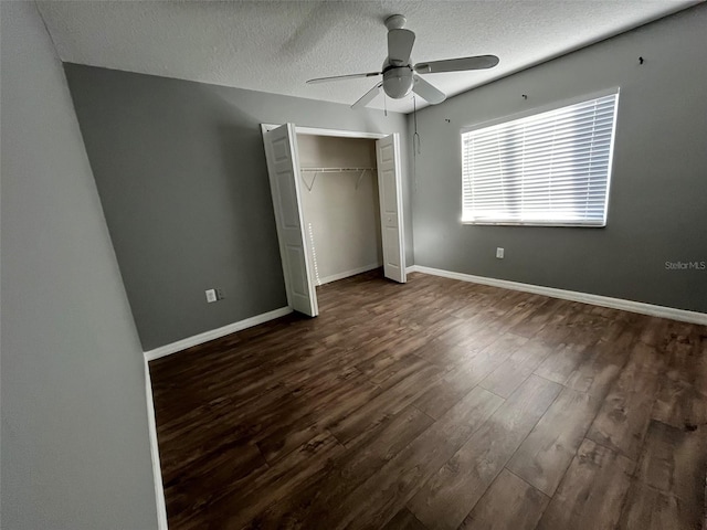 unfurnished bedroom featuring dark hardwood / wood-style floors, a textured ceiling, a closet, and ceiling fan