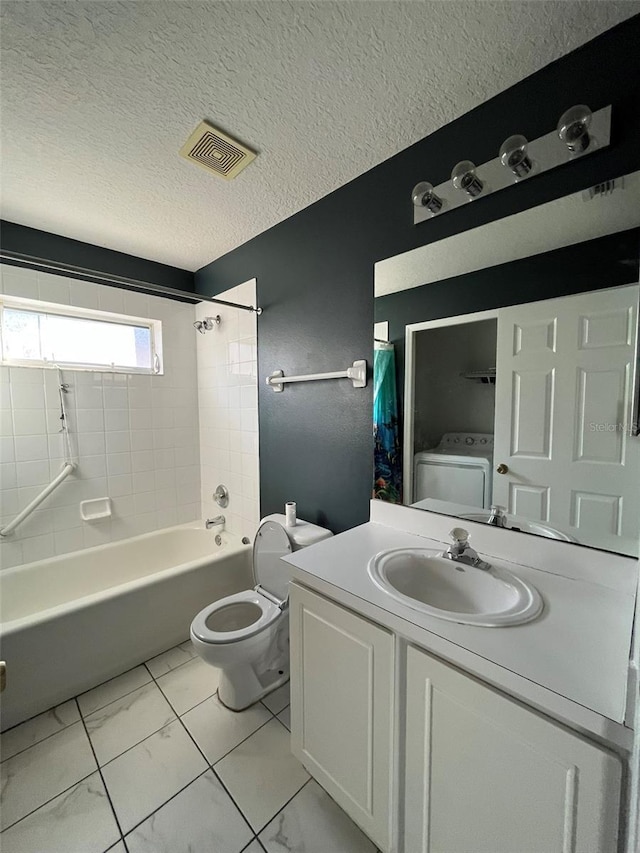 full bathroom with toilet, washer / dryer, tiled shower / bath, a textured ceiling, and vanity