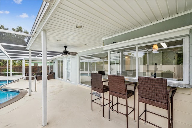 view of patio with ceiling fan, a lanai, and a fenced in pool