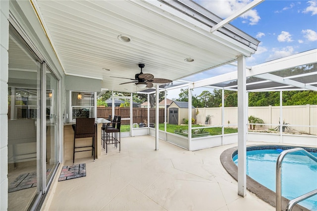 view of patio / terrace with a storage shed, a bar, and a fenced in pool