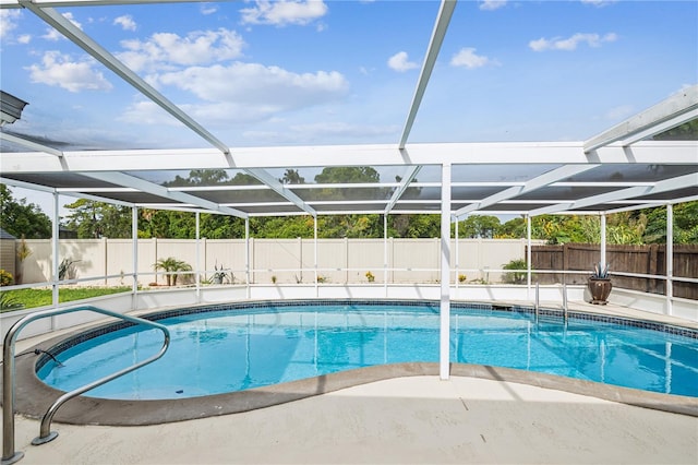 view of swimming pool with a patio area and glass enclosure