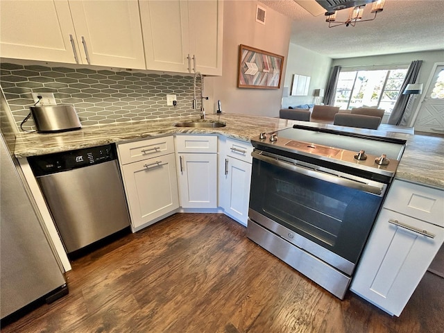 kitchen featuring backsplash, sink, light stone countertops, white cabinetry, and stainless steel appliances