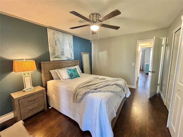 bedroom with ceiling fan, a closet, dark wood-type flooring, and a textured ceiling