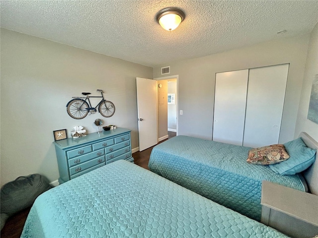 bedroom with a textured ceiling and a closet