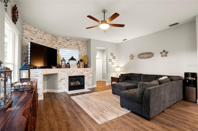 living room with ceiling fan, a healthy amount of sunlight, a fireplace, and wood-type flooring