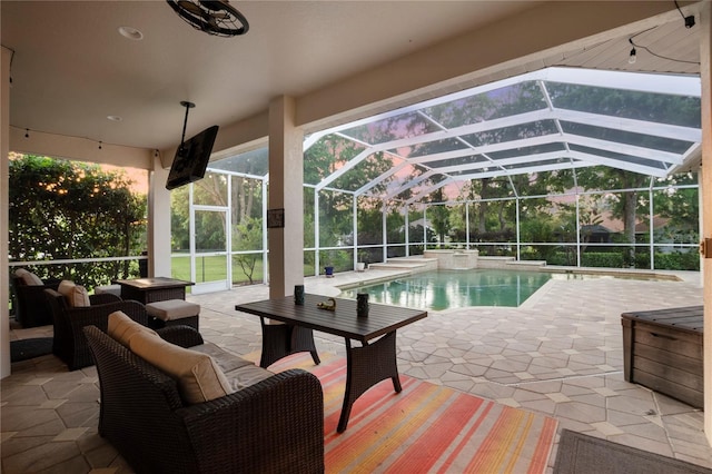 view of pool with an outdoor hangout area, a patio area, and glass enclosure