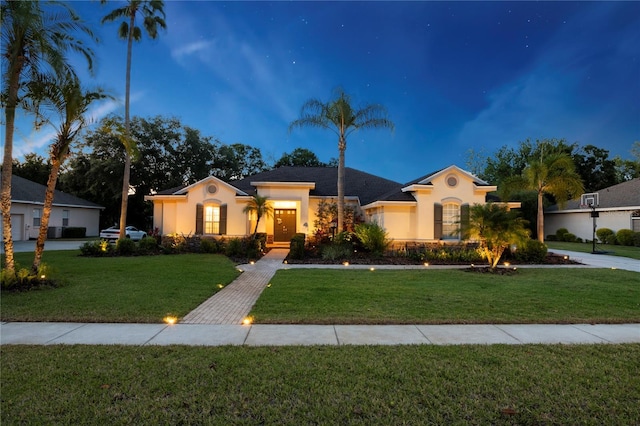 mediterranean / spanish home featuring a lawn