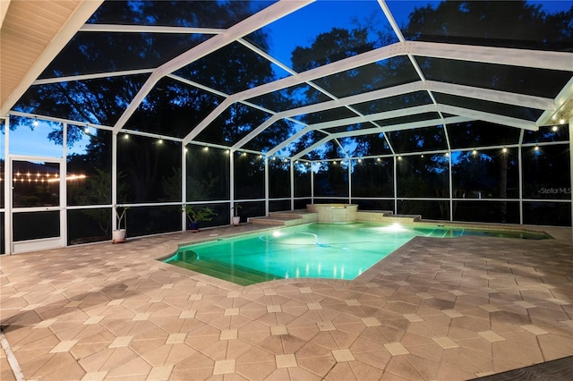 view of pool with glass enclosure and a patio area