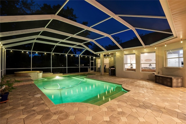 pool at twilight featuring an in ground hot tub, a lanai, and a patio