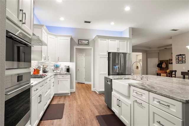 6020 Kestrel Point Ave, Lithia, FL 33547 - kitchen with appliances with stainless steel finishes, white cabinetry, decorative backsplash, recessed lighting, and light stone counters