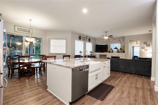 6020 Kestrel Point Ave, Lithia, FL 33547 - kitchen with dishwasher, ceiling fan, a fireplace, white cabinetry, and light stone countertops
