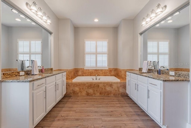 6020 Kestrel Point Ave, Lithia, FL 33547 - bathroom with two vanities, wood finished floors, a bath, and recessed lighting