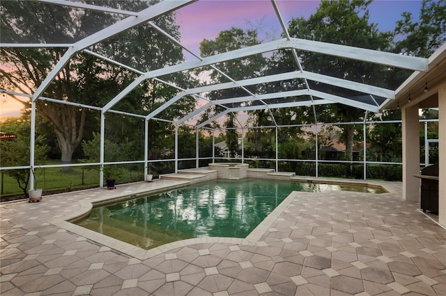 6020 Kestrel Point Ave, Lithia, FL 33547 - pool at dusk featuring a patio, a pool with connected hot tub, area for grilling, and glass enclosure