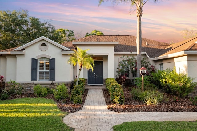 6020 Kestrel Point Ave, Lithia, FL 33547 - ranch-style house with stucco siding, a front lawn, roof with shingles, and stone siding