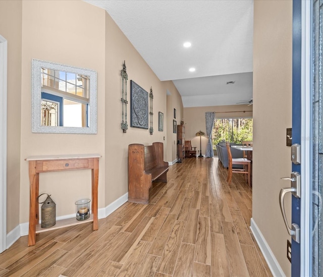 foyer featuring ceiling fan, light hardwood / wood-style floors, and lofted ceiling