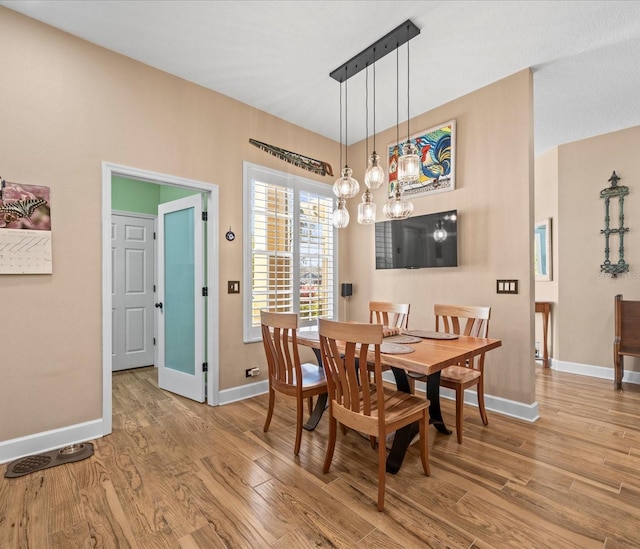 dining room featuring a chandelier and light hardwood / wood-style flooring