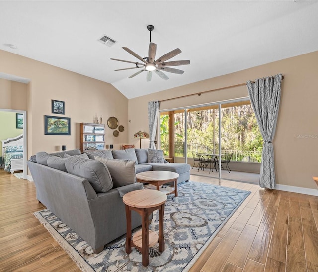 living room featuring ceiling fan, lofted ceiling, and light hardwood / wood-style flooring