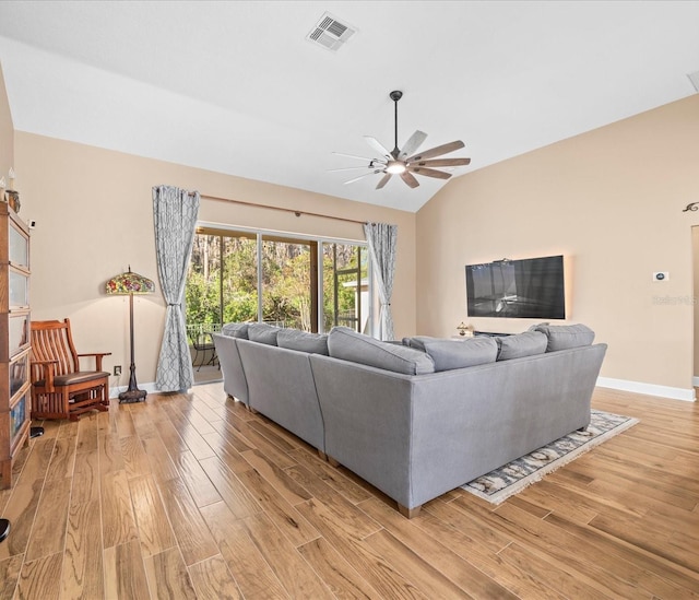 living room with ceiling fan, light hardwood / wood-style flooring, and vaulted ceiling