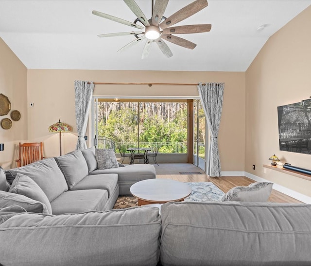 living room with light hardwood / wood-style floors, ceiling fan, and lofted ceiling