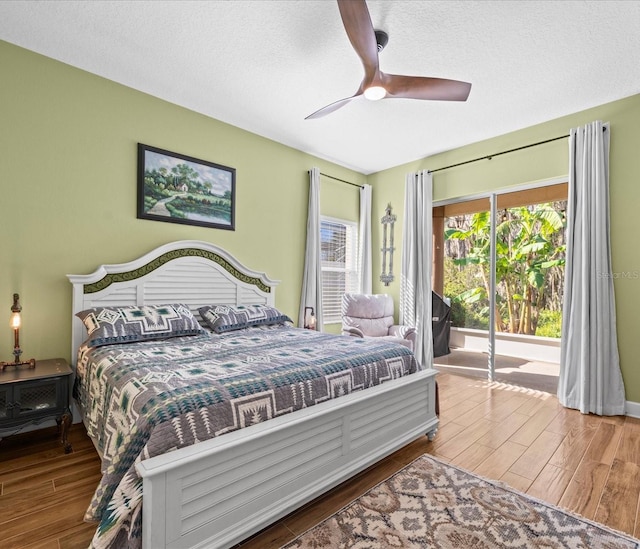 bedroom with hardwood / wood-style floors, ceiling fan, access to exterior, and a textured ceiling