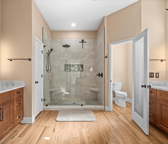 bathroom with vanity, toilet, and a shower with door