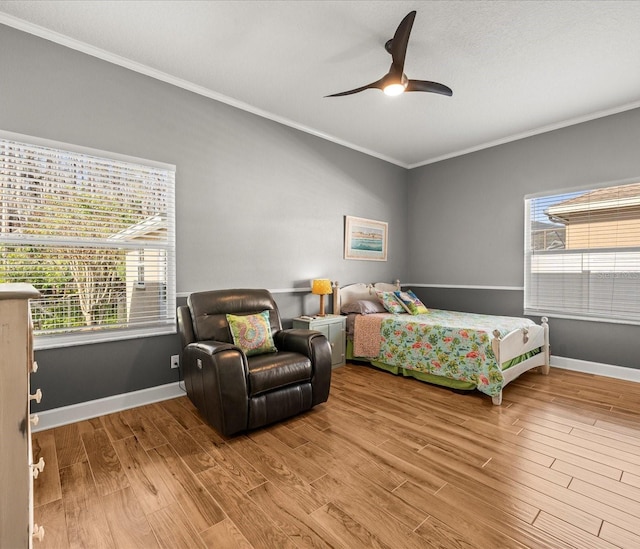 bedroom with ceiling fan, light hardwood / wood-style flooring, crown molding, and multiple windows